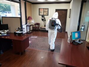 Man cleaning office in protective suit