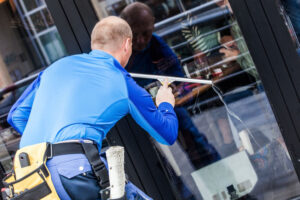 Worker washing windows in front of a commercial building