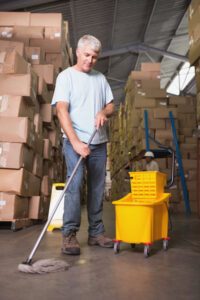 Full length of man moping warehouse floo